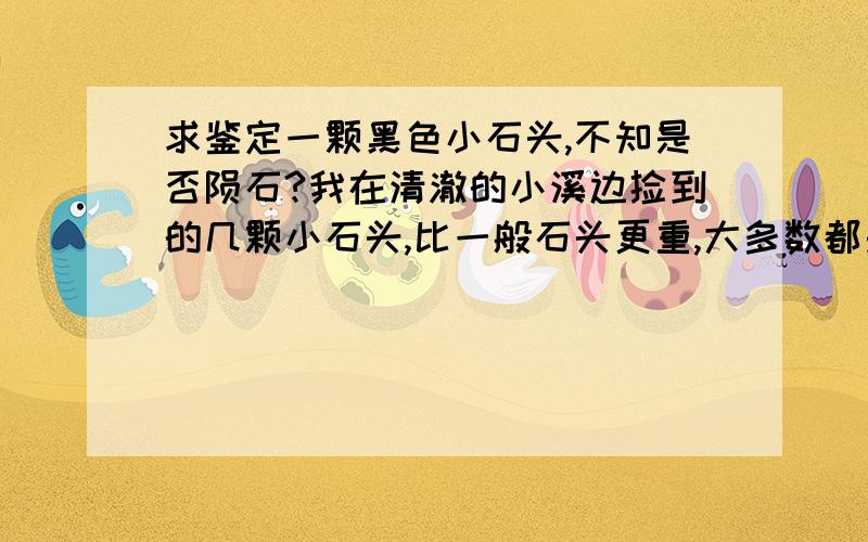 求鉴定一颗黑色小石头,不知是否陨石?我在清澈的小溪边捡到的几颗小石头,比一般石头更重,大多数都是接近圆的,表面是粗糙的小黑点,夹杂着白色石灰一样的固态物质,没有磁性.而且只在那