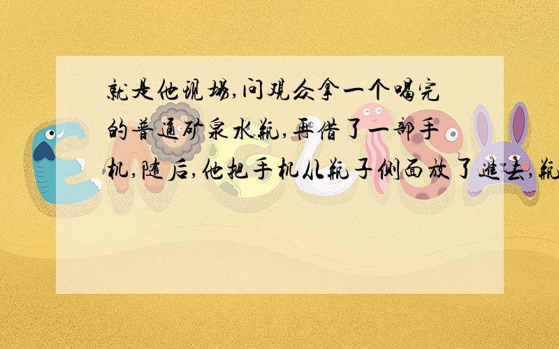 就是他现场,问观众拿一个喝完的普通矿泉水瓶,再借了一部手机,随后,他把手机从瓶子侧面放了进去,瓶子不是的,我看了一下,瓶子上没缝隙,还拿着摇了下,所以不是