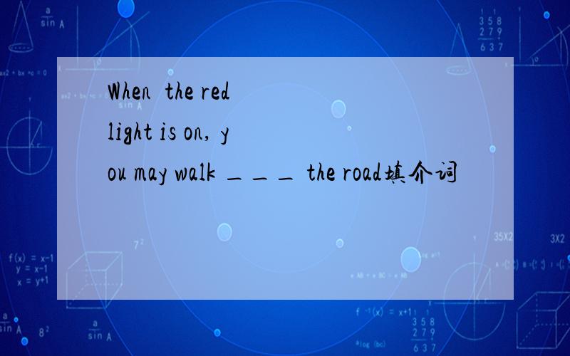 When  the red light is on, you may walk ___ the road填介词