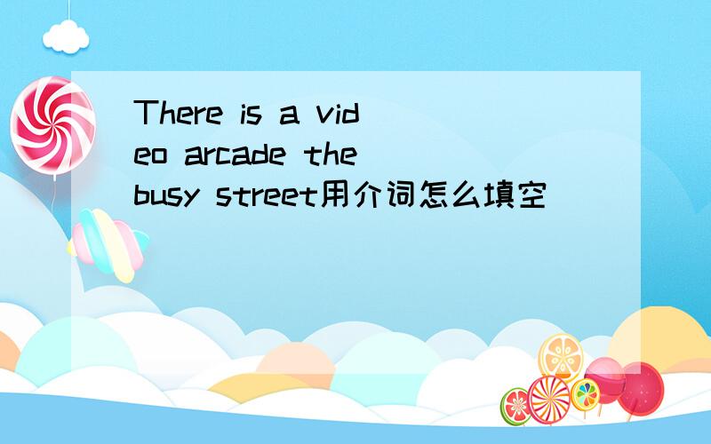 There is a video arcade the busy street用介词怎么填空