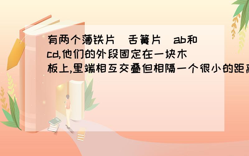 有两个薄铁片(舌簧片)ab和cd,他们的外段固定在一块木板上,里端相互交叠但相隔一个很小的距离,舌簧片连接在一个有小灯泡的电路中,如果拿一根条形磁体平行的靠近薄铁片,小灯泡就亮起来,